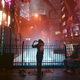 Cyberpunk 2077's V holds her hands up in the shape of a heart while looking up at Night City.